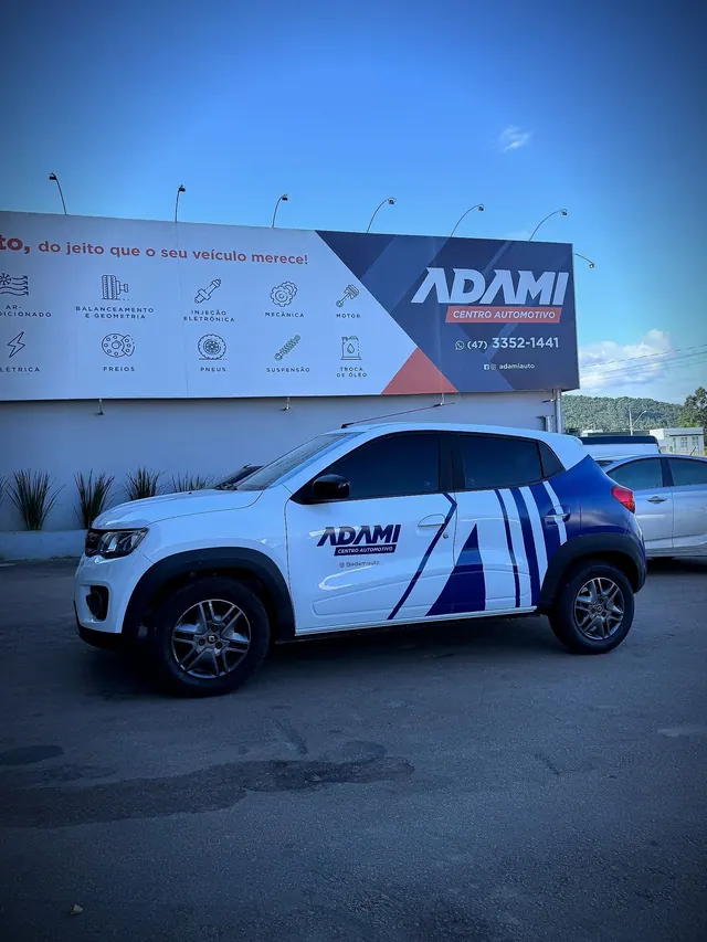 Carro adesivado Adami em frente à fachada da empresa