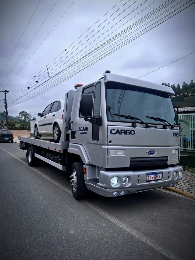 Caminhão guincho plataforma do Adami transportando um carro