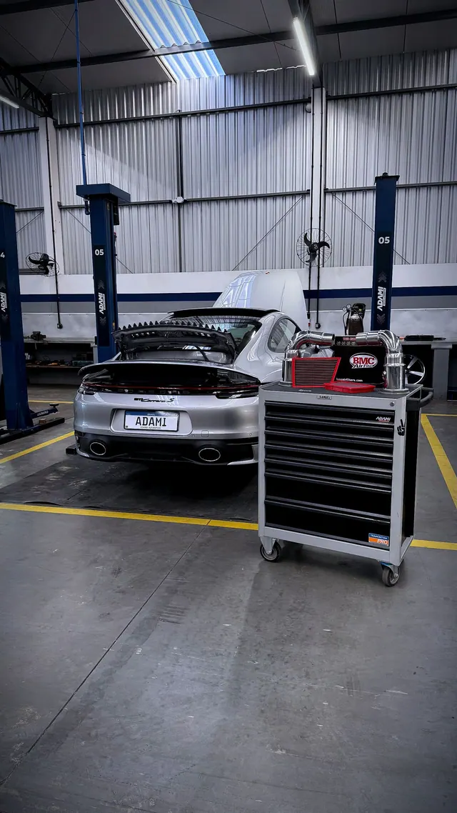 Porsche no box de serviço com carrinho de ferramentas